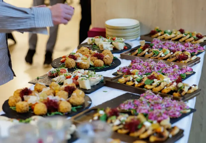 Pyszny catering na święta bożego narodzenia: przekąski z kulkami serowymi, rolkami i kanapeczkami z różowymi kiełkami.