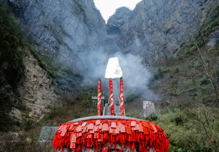 Un gran incensario con amuletos rojos cuelga ante la **puerta del cielo china**, una abertura natural en la montaña.