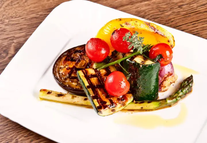 Légumes grillés au barbecue : courgettes, aubergines, poivrons, asperges, oignons rouges et tomates cerises.