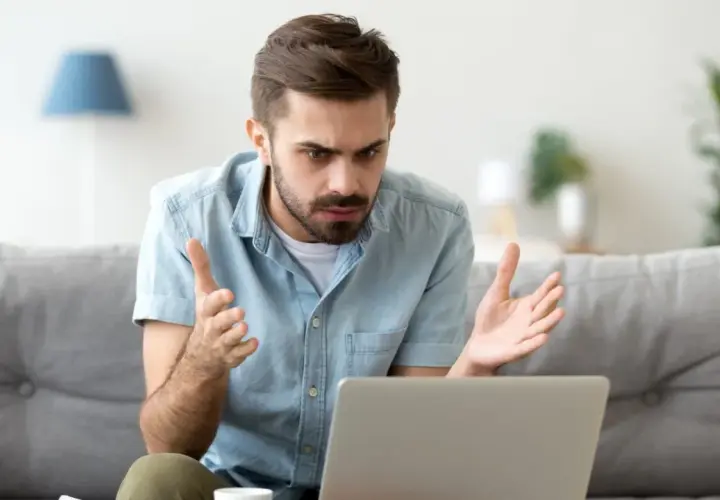 Homme perplexe devant son ordinateur, découvrant une augmentation Deezer inattendue.