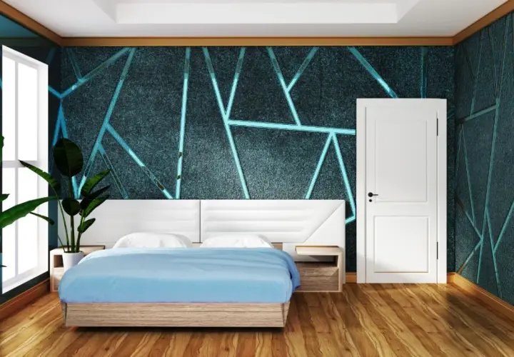 Camera da letto con un letto blu e una testiera bianca. Le pareti presentano una pittura geometrica con un motivo a forma geometrica e linee luminose.