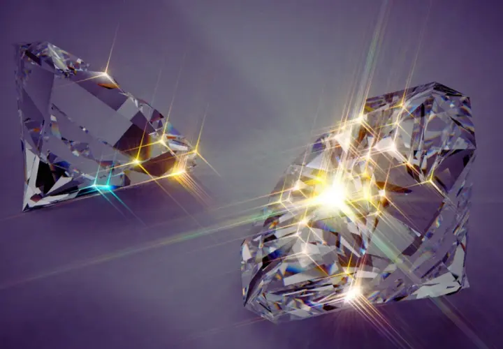 Zwei funkelnde, geschliffene Diamanten auf violettem Hintergrund. Die Lichtreflexionen deuten auf synthetische Diamanten Nachteile hin, da sie künstlich erzeugt werden.