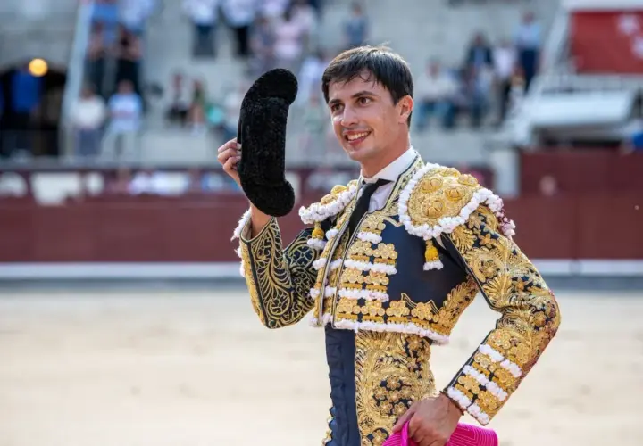 Fco José Espada, torero con traje de luces dorado y azul, saluda al público en la plaza.