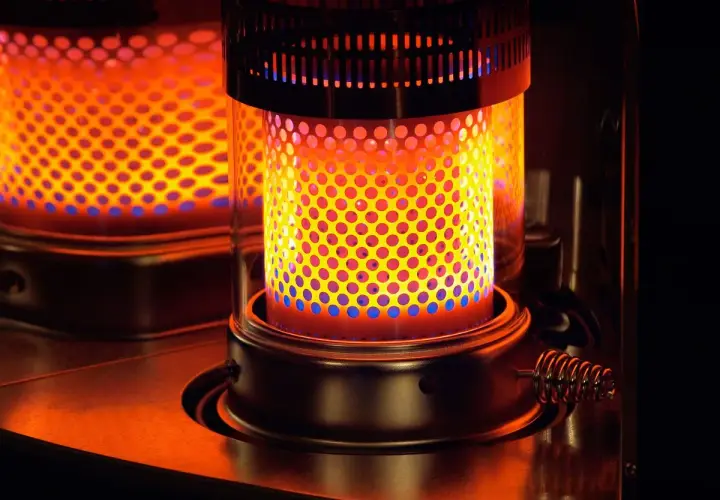 Estufa de parafina encendida, con llama naranja y azul. Considera sus pros y contras para calentar tu hogar.