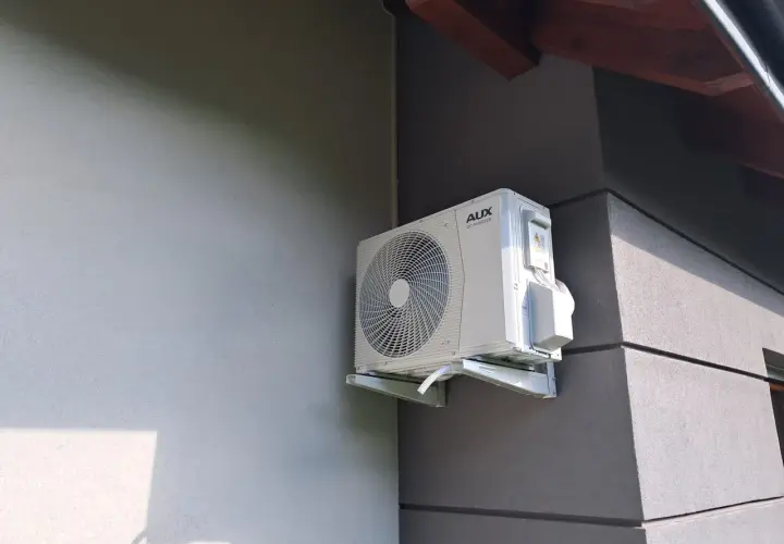 Zastanawiasz się, jaka klimatyzacja do domu będzie najlepsza? Zobacz, jak wygląda jednostka zewnętrzna klimatyzatora AUX DC INVERTER zamontowana na ścianie budynku.