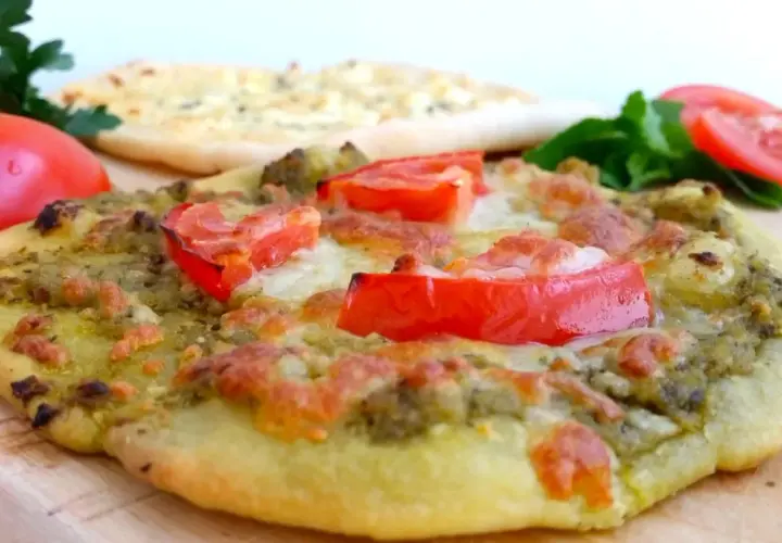 En läcker manakish ost med pesto och tomater, redo att avnjutas.