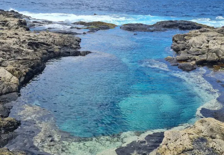 Charcones naturales de Lanzarote, piscinas de agua cristalina entre rocas volcánicas y el azul intenso del océano Atlántico.
