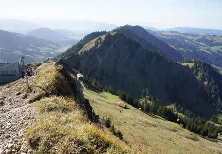 Leichte nagelfluhkette wanderung mit Blick auf grüne Täler und Berge. Ein Weg führt zu kleinen Hütten.
