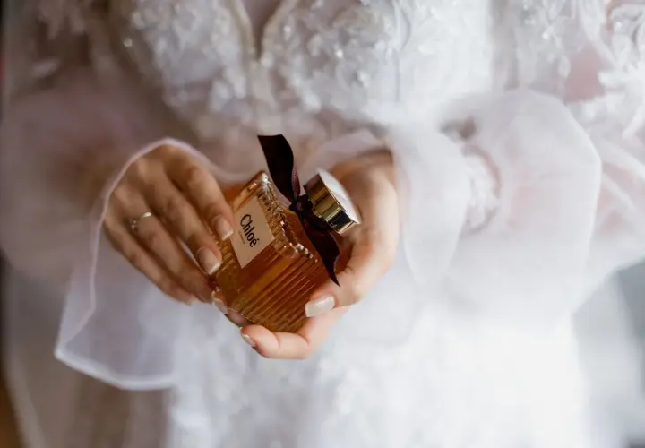 Dłonie trzymają buteleczkę perfum Chloé, idealną do ślubnego rankingu perfum damskich.