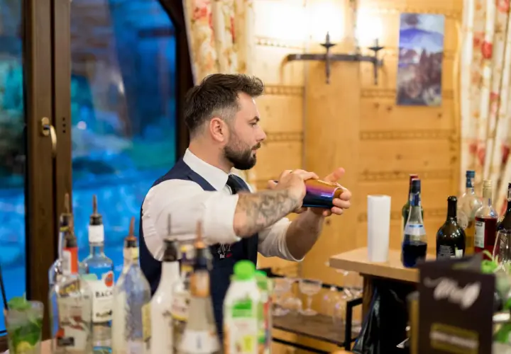 Barman na wesele, cena zależy od doświadczenia i umiejętności. Ten profesjonalista przygotowuje drinki z pasją.