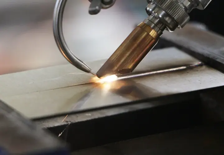 Precyzyjne spawanie laserowe aluminium, tworzące idealne połączenie dwóch elementów. Iskry i jasny łuk świadczą o wysokiej temperaturze procesu.