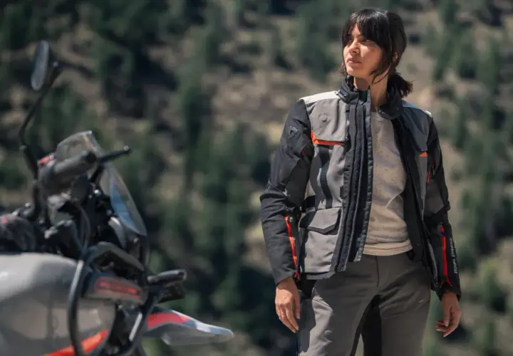 Mujer con chaqueta de moto, ideal para rutas. La diferencia entre chaqueta y cazadora se nota en su diseño funcional y protector.