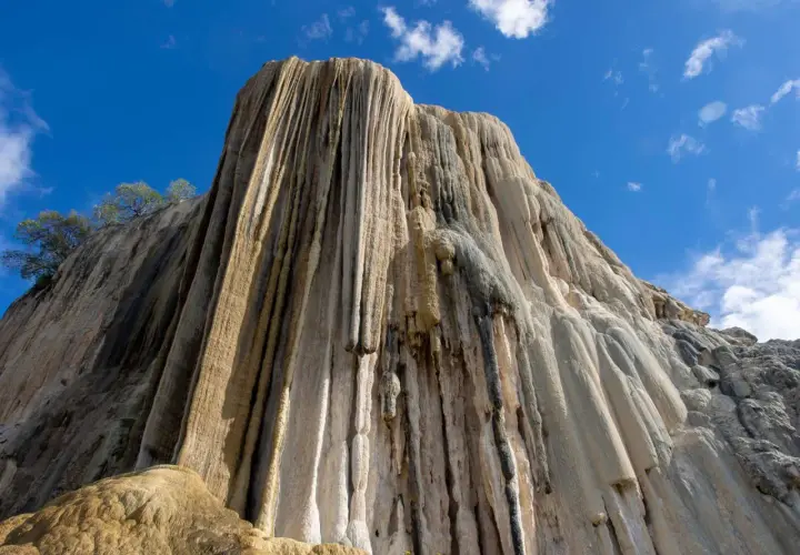 Felsformation, die aussieht, als ob hierve el agua (Wasser kocht) und über die Jahrtausende erstarrt ist. Tropfsteine bilden vertikale Säulen.