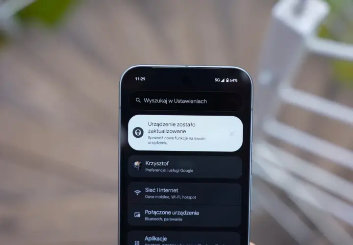 Ekran telefonu z powiadomieniem o aktualizacji systemu. Widoczne ikony sieci 5G i baterii, a także menu Ustawień z opcjami Sieć i internet, Połączone urządzenia i Aplikacje, typowe dla systemu android 16.