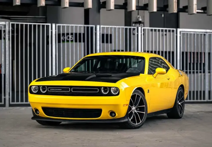 Żółty Dodge Challenger z czarną maską, idealny na letnie przejażdżki. Sprawdź jego atrakcyjną dodge challenger cena!