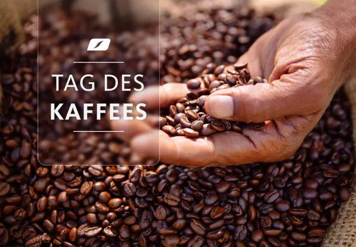 Eine Hand hält geröstete Kaffeebohnen vor einem Sack voller Bohnen. Der Text "TAG DES KAFFEES" ist überlagert.