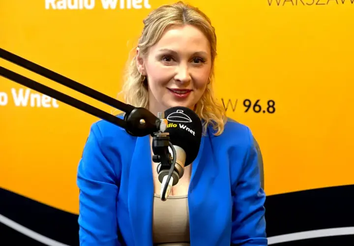 Joanna Miziołek, w wieku około 40 lat, w niebieskiej marynarce, przed mikrofonem Radia Wnet.