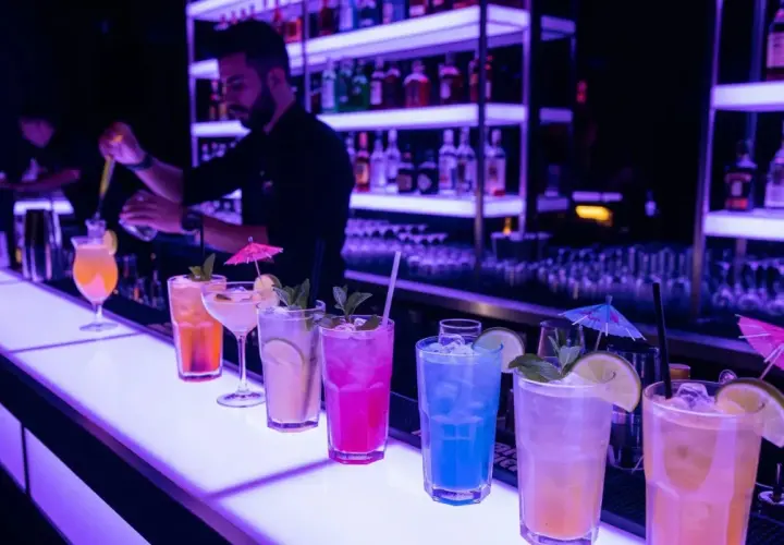 Kolorowe drinki na barze, barman przygotowuje kolejny. Idealne miejsce na relaks i smakowanie wyśmienitego **alkoholu** na **Malcie**.