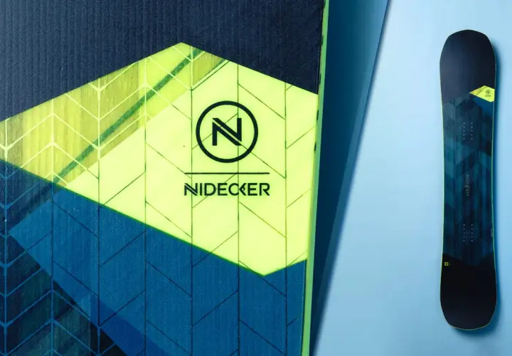 Zbliżenie na deskę snowboardową Nidecker z logo i geometrycznym wzorem.