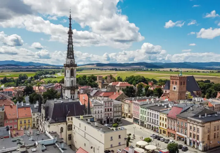 Widok na rynek i wieżę ratuszową w Ząbkowicach Śląskich. W tle pola i góry.