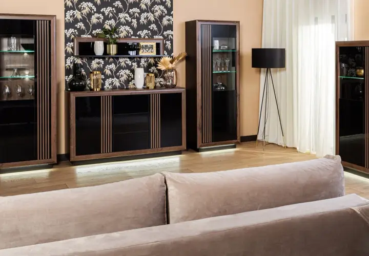 Elegancka komoda i witryny z ciemnego drewna, ozdobione pionowymi lamelkami, tworzą stylowy zestaw mebli.