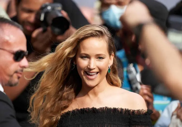 Jennifer Lawrence, uśmiechnięta, otoczona przez paparazzi. Ciekawe, ile lat ma Jennifer Lawrence, gdy robi taką karierę?