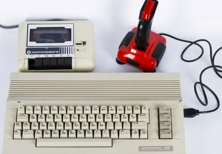 Commodore 64 z magnetofonem i joystickiem, idealny do tworzenia muzyki elektronicznej lat 80. zespoły.