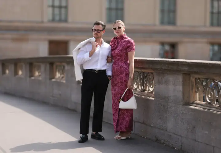 Para w eleganckich strojach pozuje na tle kamiennej balustrady.