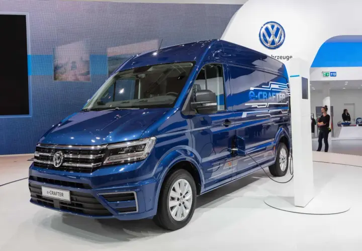 Niebieski elektryczny kamper e-Crafter podłączony do ładowarki.