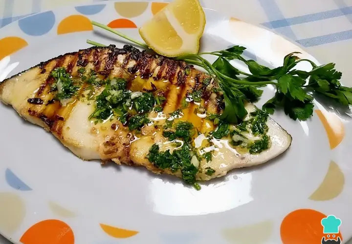 Filete de pez espada a la parrilla con perejil picado y limón.