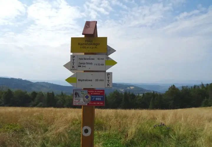 Rozdroże szlaków turystycznych. Tabliczka informuje o wysokości 1100 m n.p.m. i kierunkach do Hali Barankowej, Zawoi Składów i Mędralowej. To punkt startowy na szlak na Halę Kamińskiego.