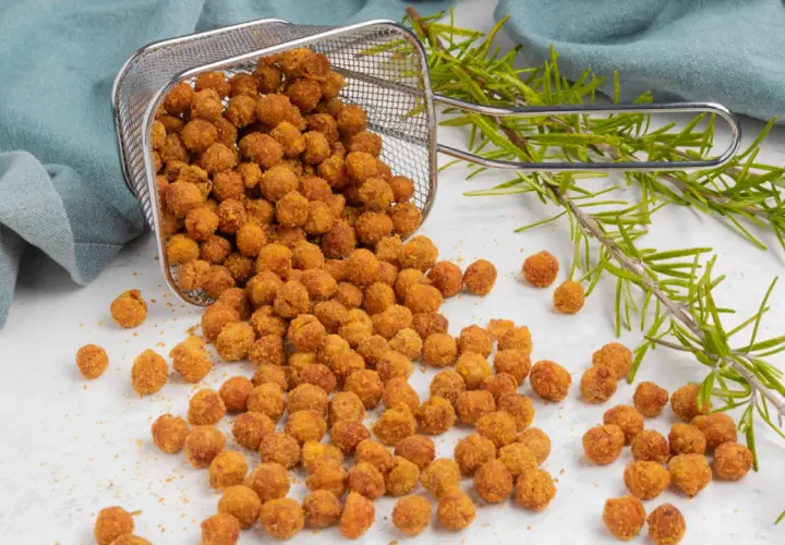 Ceci croccanti in friggitrice ad aria, appena usciti dal cestello, con rametti di rosmarino.