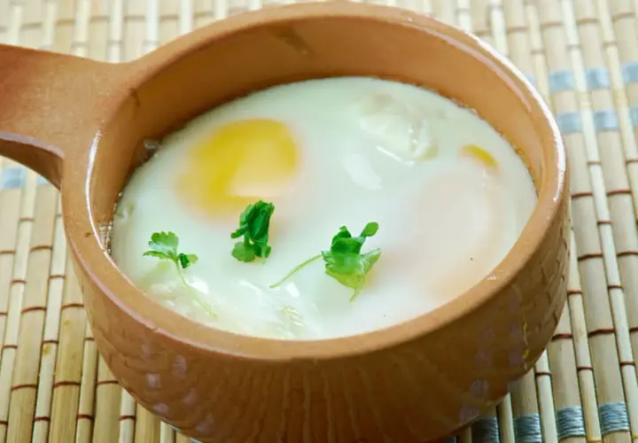 Un œuf cocotte crémeux, cuit au four, garni de persil frais. Un délice simple et réconfortant.