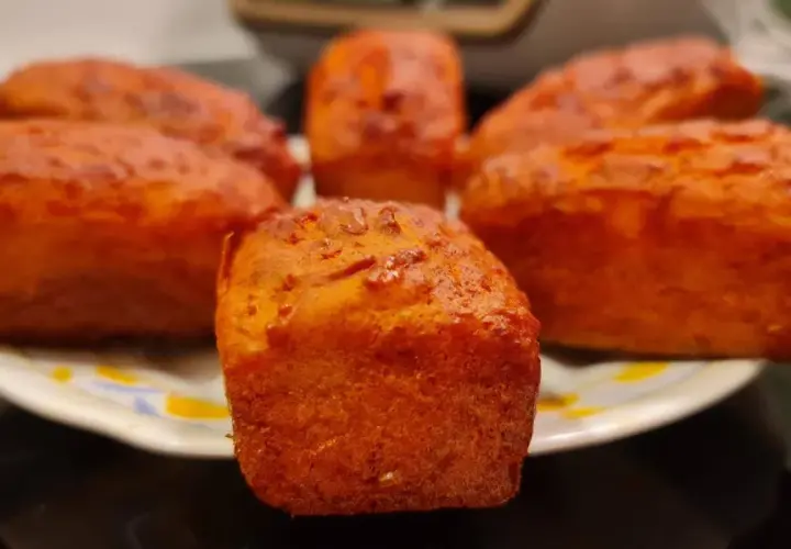 Petits pains dorés, peut-être un cake chorizo, sur une assiette.