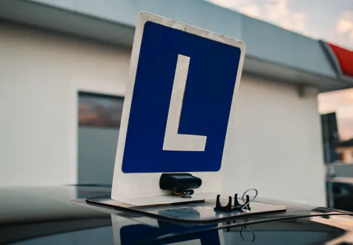 Tablica z literą "L" na dachu samochodu, symbolizująca naukę jazdy. Czy można zobaczyć nagranie z egzaminu na prawo jazdy?