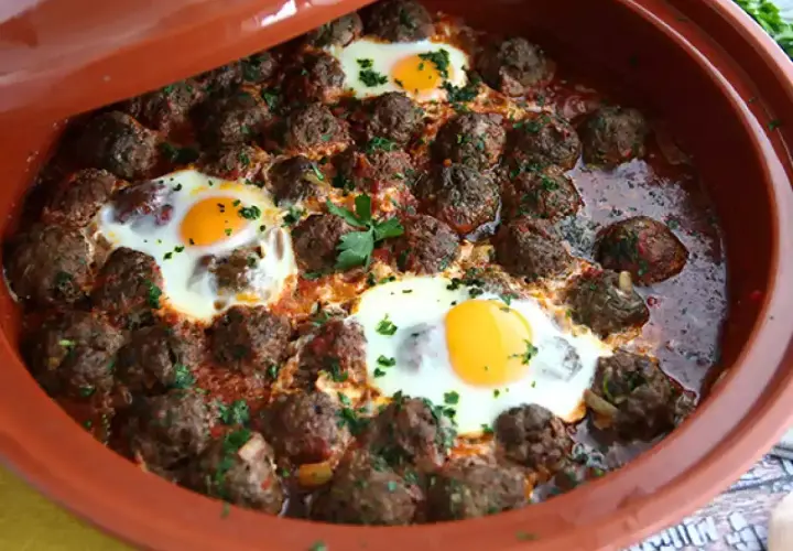 Köttbullar med ägg i tomatsås i en tagine. Ett smakrikt tagine recept som passar perfekt för en mysig middag.