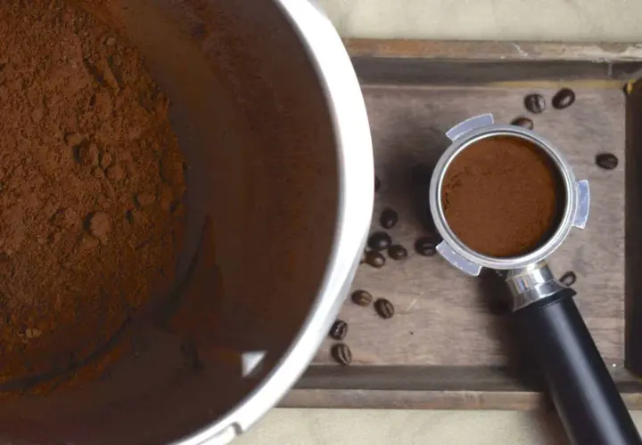Frisch gemahlene Kaffeebohnen im Thermomix-Behälter und im Siebträger. Der Duft von frisch gemahlenem Kaffee liegt in der Luft.