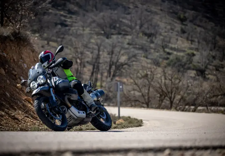 Motociclista en curva, con casco y equipo de aventura. Las llantas Continental TKC 70 opiniones son clave para este terreno.