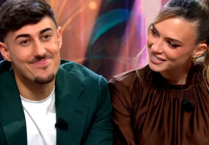 Almudena y Borja, sonriendo y mirando hacia un lado. Él lleva una chaqueta verde y ella un vestido marrón.