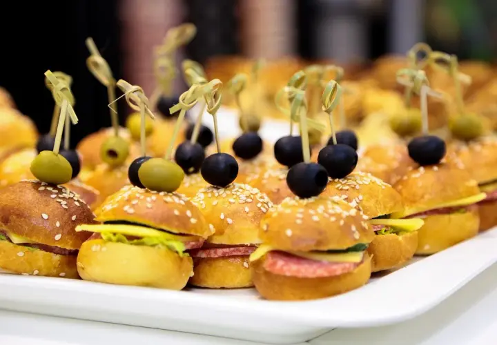 Mini kanapki na przyjęcie, idealne na catering w Warszawie. Mini burgery z oliwkami i sezamem.