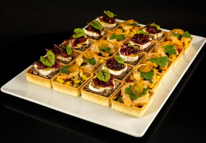 Elegancki catering na konferencje: tartaletki z krewetkami i mango oraz z kozim serem i konfiturą z czerwonej cebuli.