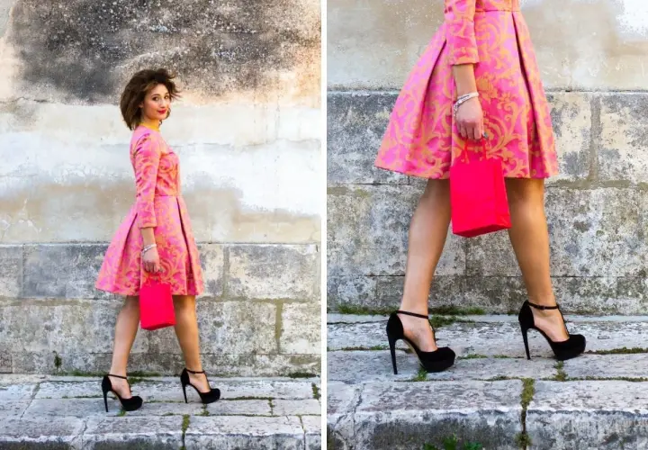 Elegancka kobieta w różowej sukience z złotym wzorem i czarnymi szpilkami. Idealne buty do różowej sukienki na specjalne okazje.