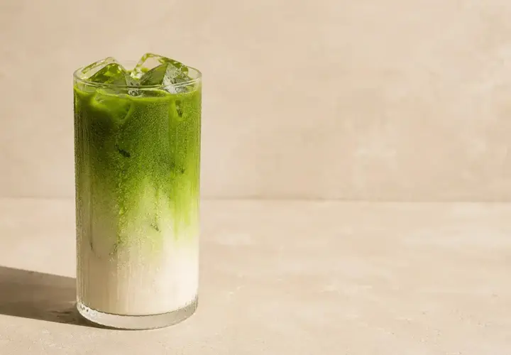 Orzeźwiający napój matcha latte z lodem w szklance. Idealny, gdy zastanawiasz się, jak zrobic matche.