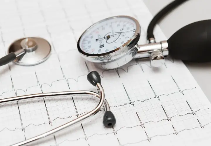 Stetoskop i ciśnieniomierz na tle EKG. Dbanie o serce, jak przyjmowanie leku Valsacor, jest kluczowe.