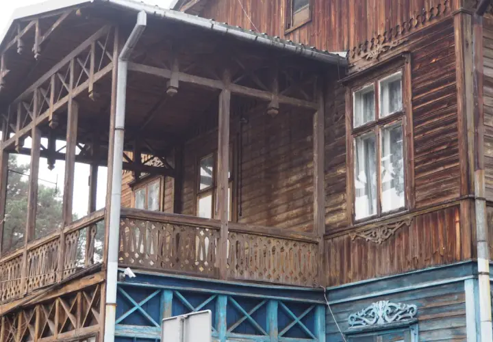 Drewniana willa z werandą, ozdobnymi balustradami i okiennicami, część szlaku świdermajerów.