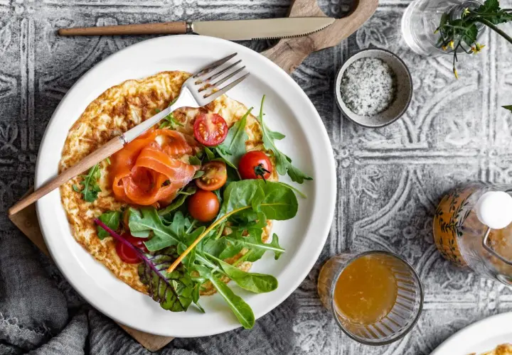 Pyszny omlet na słono z łososiem, pomidorkami i rukolą. Idealny na śniadanie lub lekki lunch.