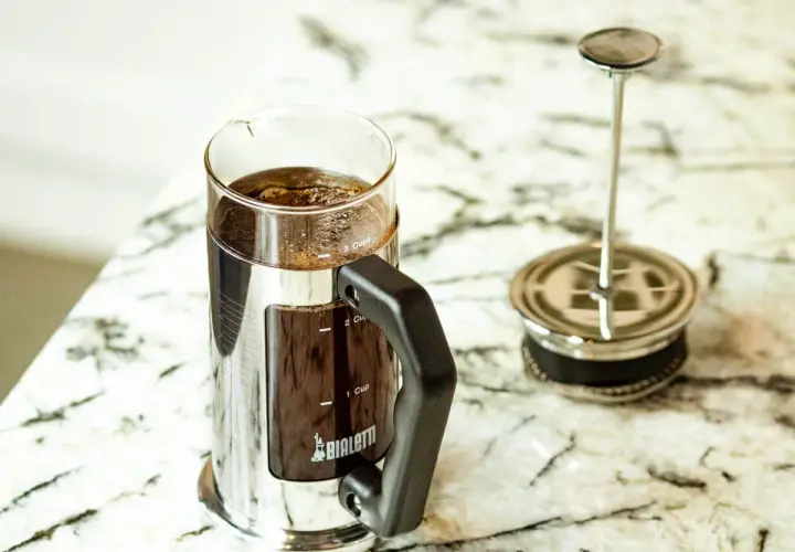 Elegancka kawiarka Bialetti z zaparzoną kawą po francusku. Gotowa do delektowania się aromatycznym napojem.