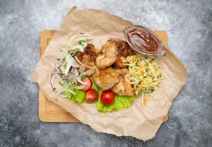 Grillowany kurczak z surówką z kapusty, cebulą, pomidorkami i sosem.