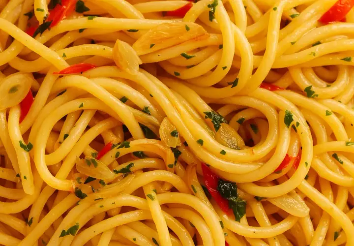 Nahaufnahme von Spaghetti Aglio e Olio, dem originalen Gericht mit Knoblauch, Chili und Petersilie.