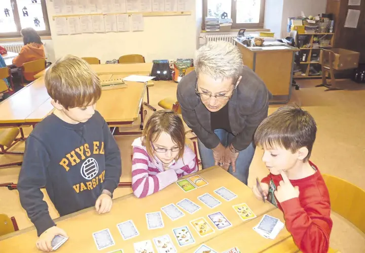 Lehrerin erklärt Kindern beim Projekttag Grundschule ein Kartenspiel.